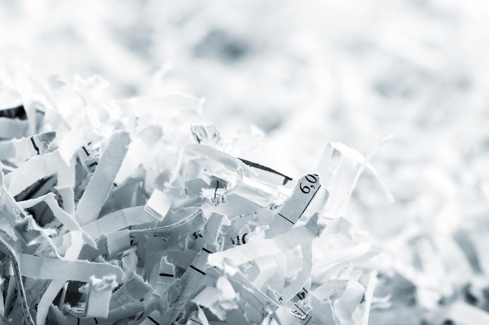 Geschredderte Papierstreifen nach DSG-konformer Aktenvernichtung gemäss DIN 66399 und ISO/IEC 21964