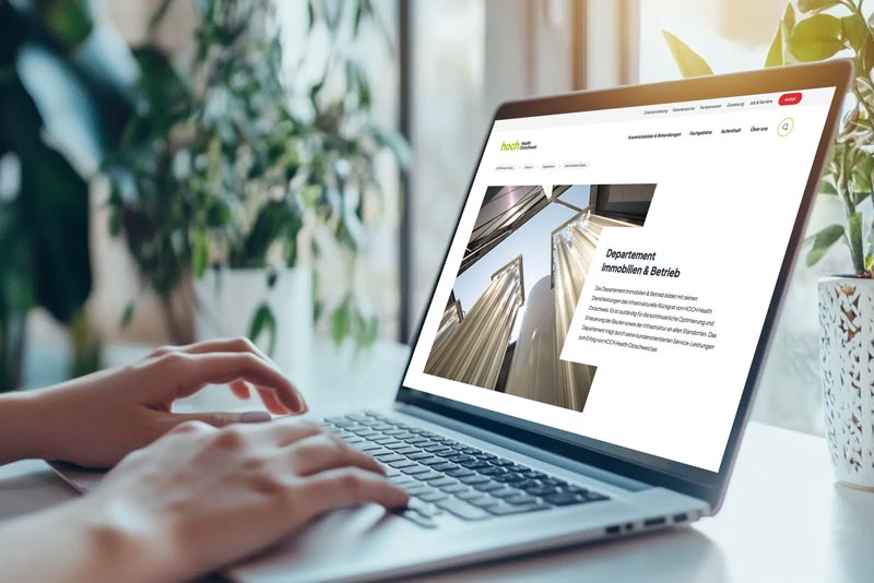 Zusammenarbeit mit HOCH Health Ostschweiz Laptop mit geöffneter Webseite des Departements Immobilien & Betrieb von HOCH Health Ostschweiz