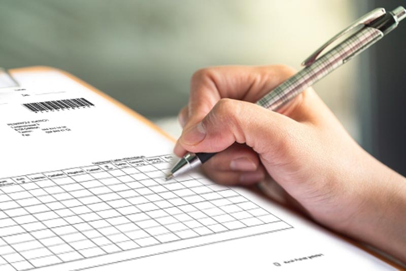 Zertifizierter Nachweis der DSG-konformen Aktenvernichtung durch Vernichtungszertifikat. Hand füllt Vernichtungsprotokoll aus – Nachweis für datenschutzkonforme Aktenvernichtung